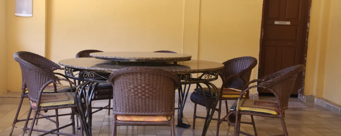 Sala de convivência com mesas redondas e cadeiras