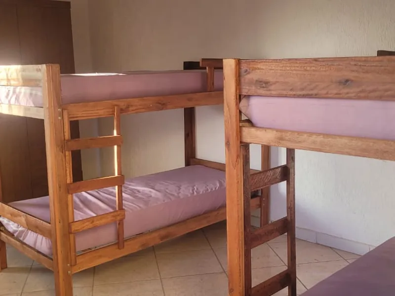 Quarto com beliches de madeira e roupa de cama