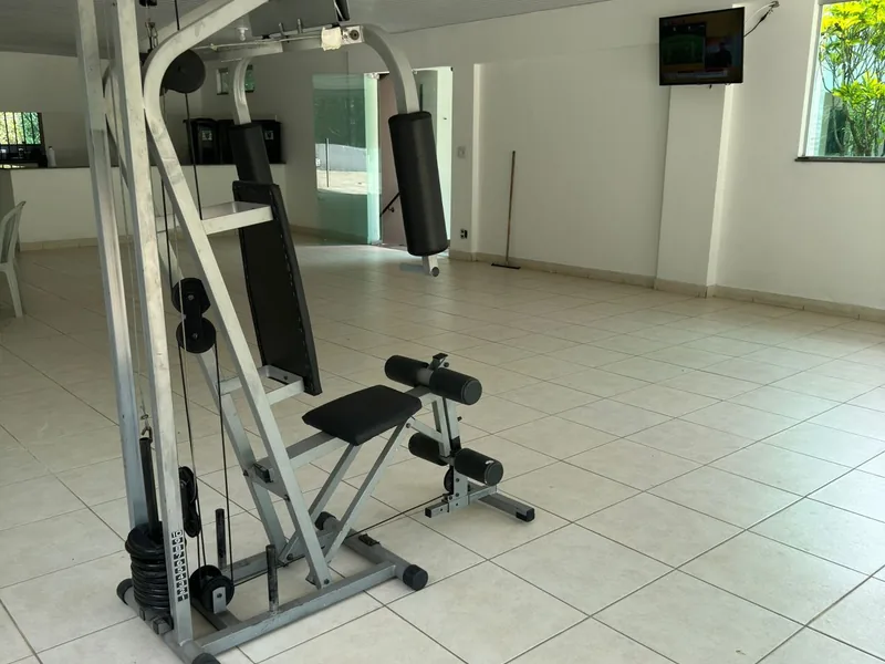 Sala com aparelho de musculação e piso claro