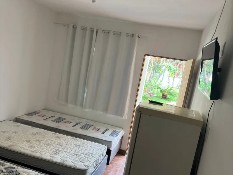 Quarto com cama, janela com cortina e armário