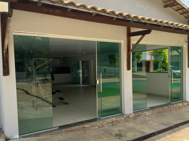 Área coberta com portas de vidro voltadas para o jardim
